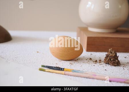 Egg on a table with paintbrushes and clay Stock Photo