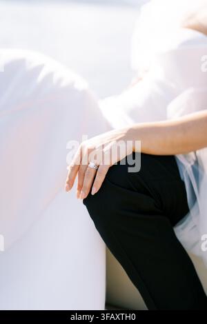 Close up of bride hand with engagement ring on groom knee Stock Photo