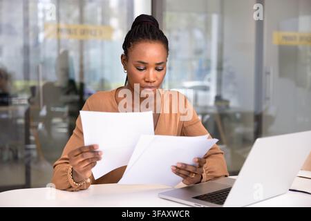 Serious African office employee do paperwork at workplace Stock Photo