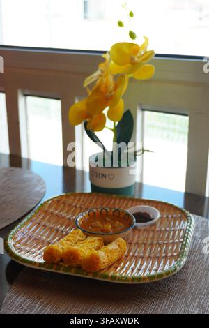 Roti Jala Set on Dining Table With Yellow Orchid Decoration, Window Light Stock Photo