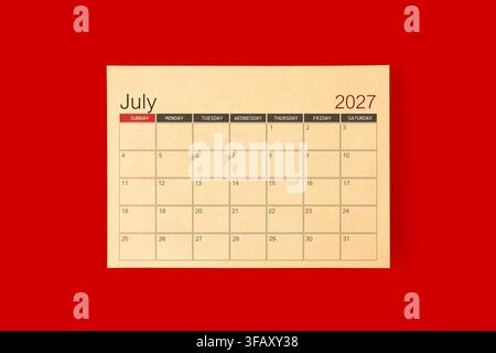 July 2027 desk calendar made from brown paper page on red color background. Stock Photo