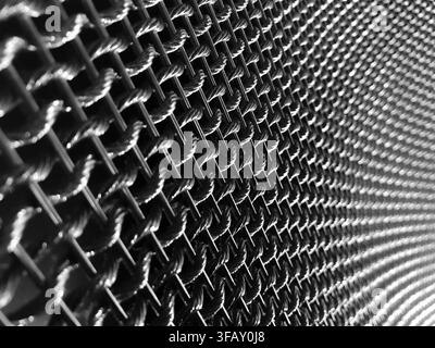 Black and white abstract background of architectural woven wire mesh with repeating pattern. Stock Photo
