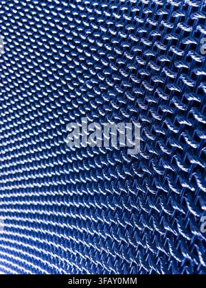 Blue woven fabric texture macro with repeating grid pattern, abstract geometric background for technology or industrial design. Stock Photo