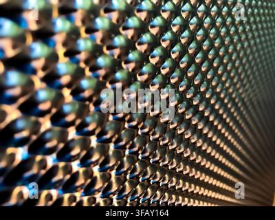 Abstract macro of metallic textured surface with blue and copper reflections, diagonal pattern creating futuristic industrial background. Stock Photo