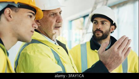 Building, inspection and men with supervisor, teamwork and plan for renovation on construction site. Civil engineer, people and collaboration for Stock Photo
