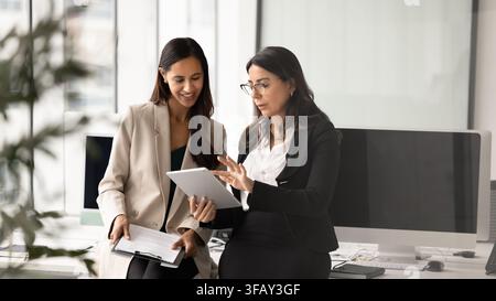 Team members working on project using digital tablet during briefing Stock Photo