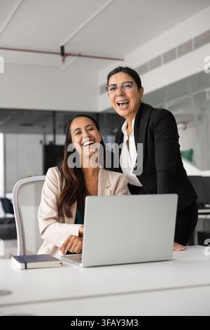 Diverse businesswomen, team members laughing, looking at camera Stock Photo