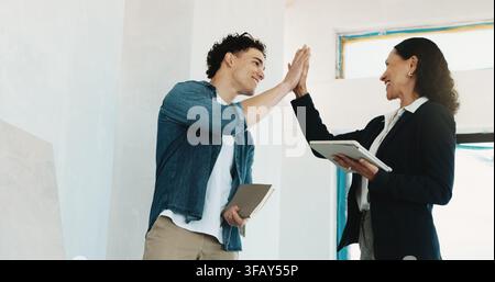 High five, tablet and inspection team on site for building, maintenance or repairs in collaboration. Technology, happy people and civil engineers with Stock Photo