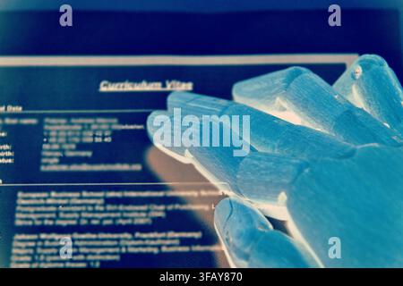 Robotic Hand Reviewing a Curriculum Vitae Stock Photo