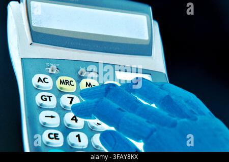 A robotic hand using a calculator, symbolizing artificial intelligence, automation, digital computation, and the integration of advanced technology in Stock Photo