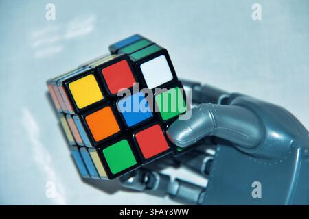 Robotic Hand Holding a Colorful Rubik's Cube, AI and Problem Solving Concept Stock Photo
