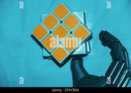 Robotic Hand Holding a Rubik’s Cube Stock Photo