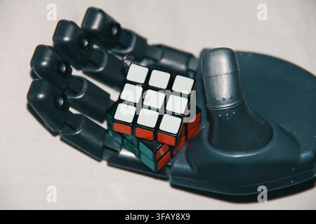 Blue Robotic Hand Holding a Rubik's Cube, Artificial Intelligence and Problem Solving Concept Stock Photo
