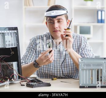 The young technician repairs computers in the workshop Stock Photo