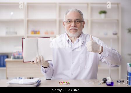 Old chemist working in laboratory Stock Photo