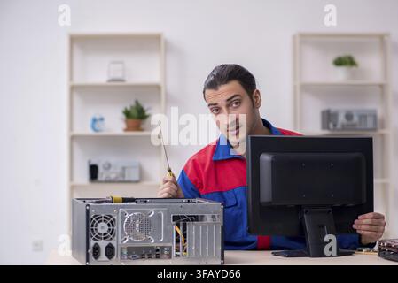 Young male mechanic repairs computer PC Stock Photo