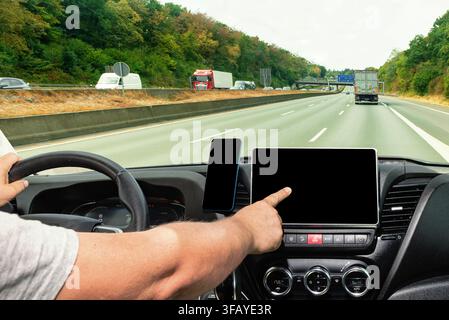 Close up of a man using navigation or infotainment digital dashboard system during a vehicle trip Stock Photo