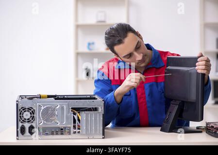 Young male mechanic repairs computer PC Stock Photo