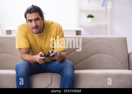 Young man playing joystick games at home Stock Photo