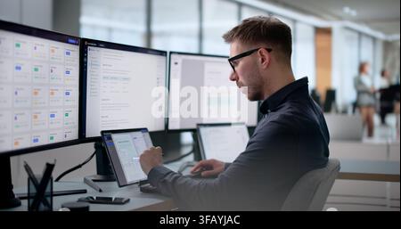 Young Software Engineer Uses Laptop To Build AI-powered Knowledge System. Stock Photo