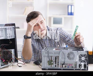 The young technician repairs computers in the workshop Stock Photo