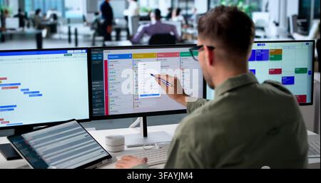 Agile Project Manager Studies Digital Scrum Board Tasks On Laptop Screen. Stock Photo
