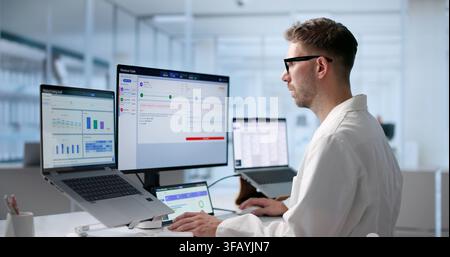 Young Man Reviews Medical Claims On Laptop To Ensure Accurate Reimbursement. Stock Photo
