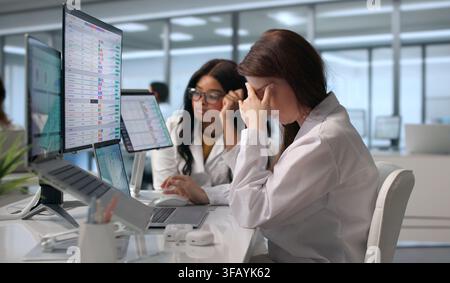 Tired Healthcare Coder Reviews Billing Invoices While Rubbing Her Headache. Stock Photo