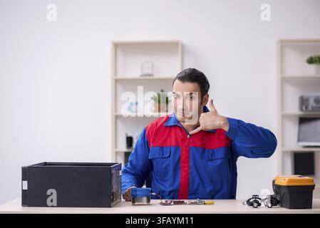 Young male mechanic repairs computer PC Stock Photo