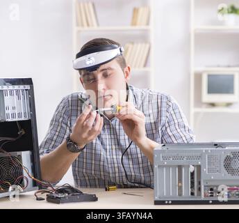 The young technician repairs computers in the workshop Stock Photo