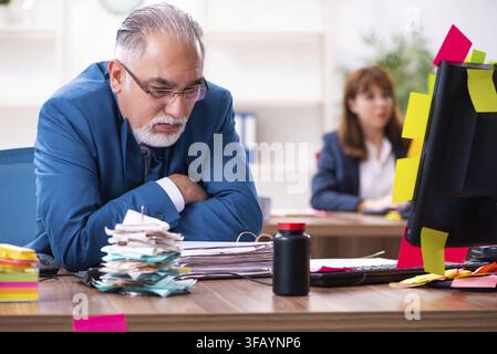 Two employees and excessive work in the office Stock Photo