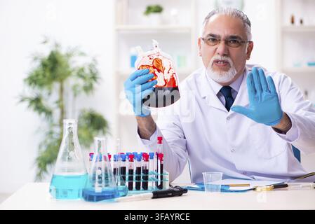 Old chemist working in laboratory Stock Photo