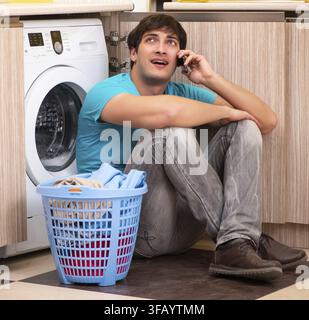 The young man doing laundry at home Stock Photo