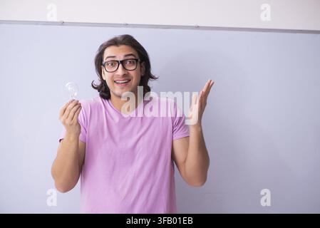 Young male student in front of the board Stock Photo