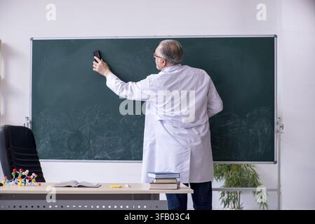 Experienced old scientist working in laboratory Stock Photo