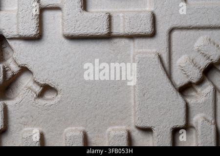 Macro background texture of molded paper pulp packaging tray. Detailed close up top view of textured grey molded pulp packaging insert box container w Stock Photo