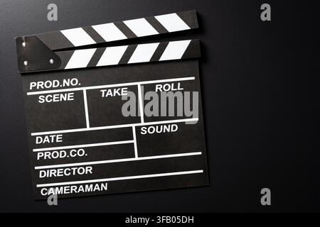 Black movie clapperboard on dark background, close up. Top view of classic film slate clapper board on black background, cinema and video production c Stock Photo
