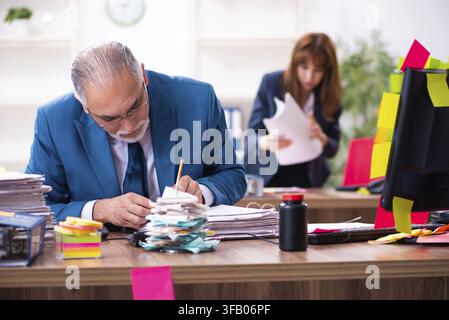Two employees and excessive work in the office Stock Photo