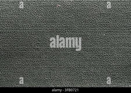 Dark textured plastic surface close up. Macro view of dark grey or black rough textured plastic material surface suitable for background or industrial Stock Photo