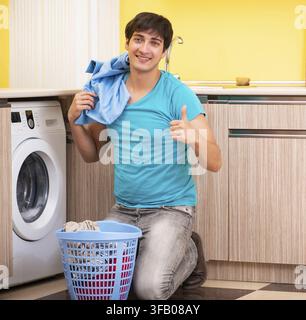 The young man doing laundry at home Stock Photo
