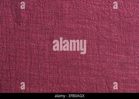 Burgundy linen fabric texture macro background. Close up of dark red burgundy woven linen textile surface filling the frame with its raw natural fiber Stock Photo