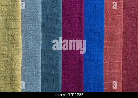 Colorful crinkled linen fabric texture background, close up. Top view of various multicolored cotton or linen textile scarfs with wrinkled texture arr Stock Photo