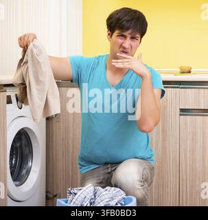 The young man doing laundry at home Stock Photo