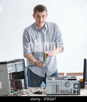 The young technician repairs computers in the workshop Stock Photo