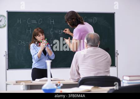 Old teacher and two students in the classroom Stock Photo