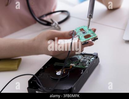 The engineer repairs a broken computer hard drive Stock Photo