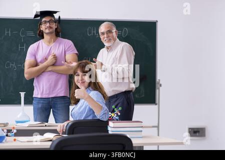 Old teacher and two students in the classroom Stock Photo
