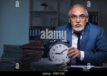Old employee working late in the office Stock Photo