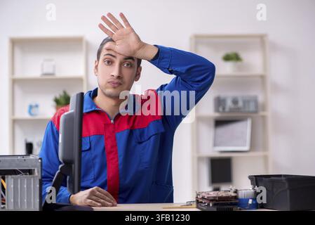 Young male mechanic repairs computer PC Stock Photo