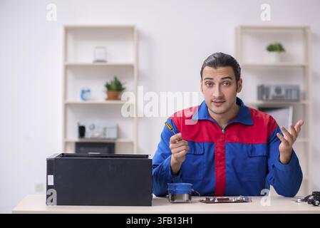 Young male mechanic repairs computer PC Stock Photo